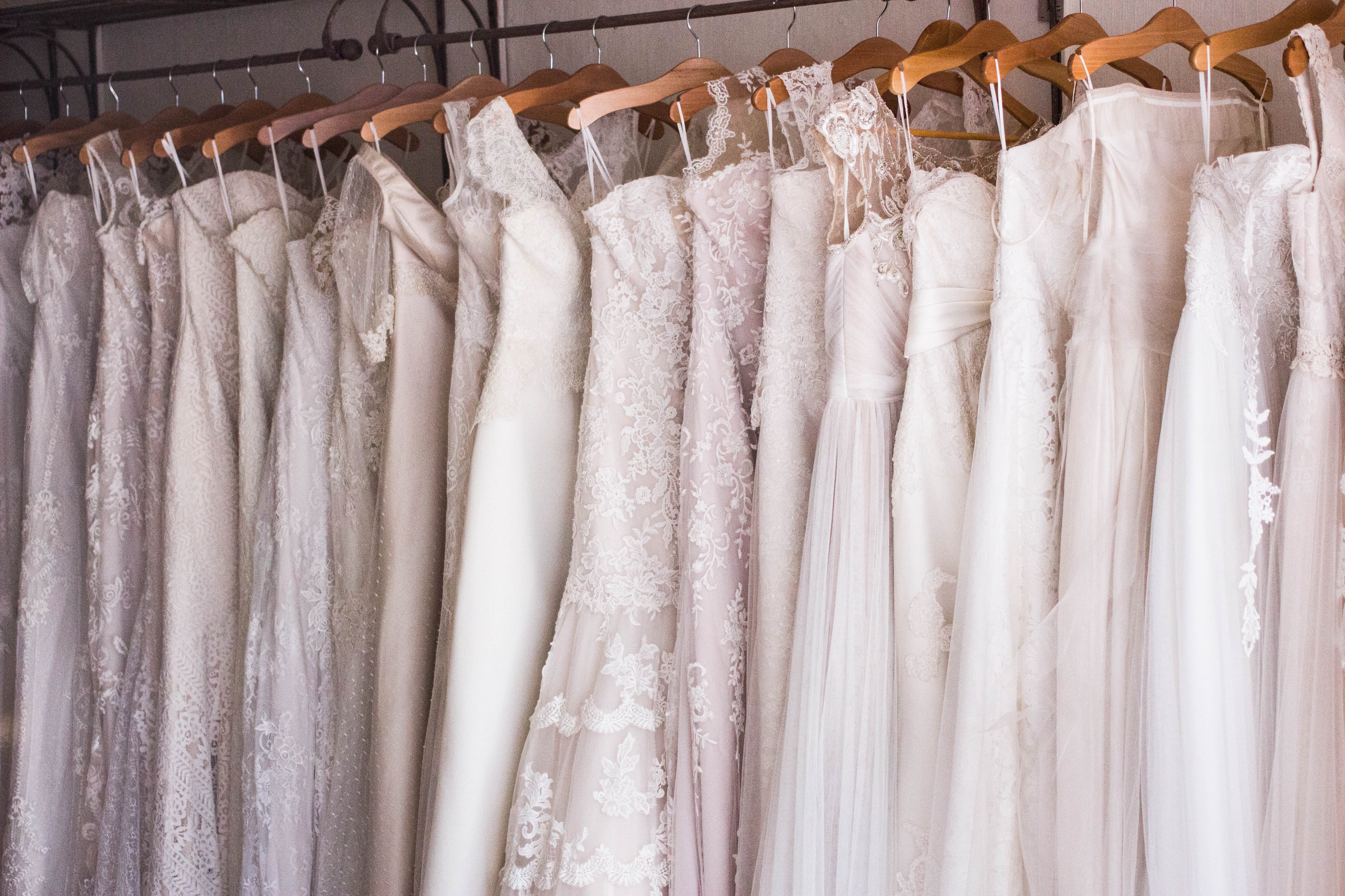 wedding dresses hung up in a row