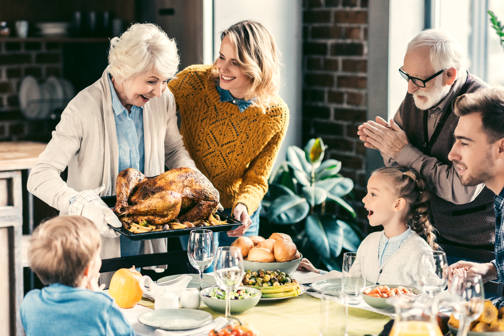 Grandma holding a turkey and bringing it to Thanksgiving dinner