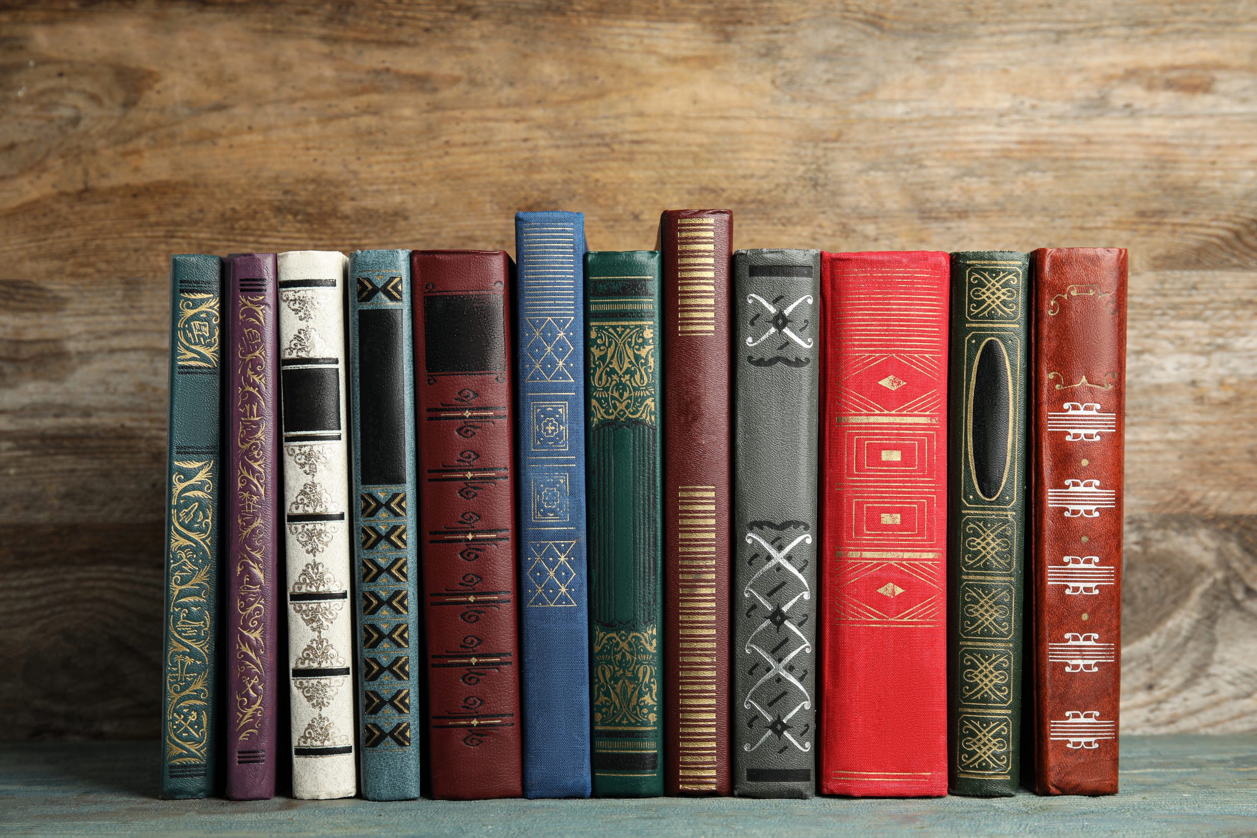 BOOKS LINED UP ON A SHELF.