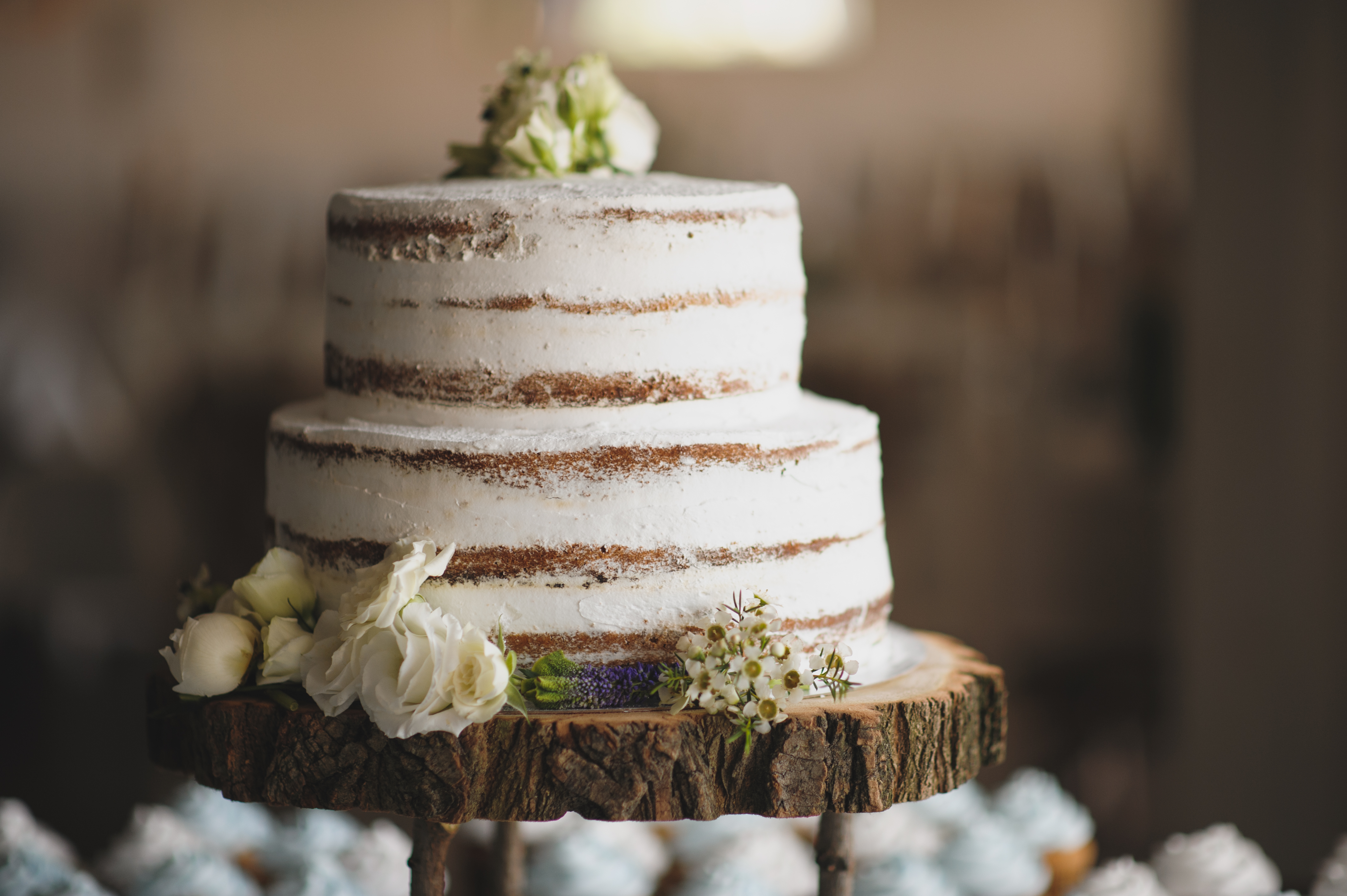 beautiful wedding cake with moss and on top of a piece of a tree trunk