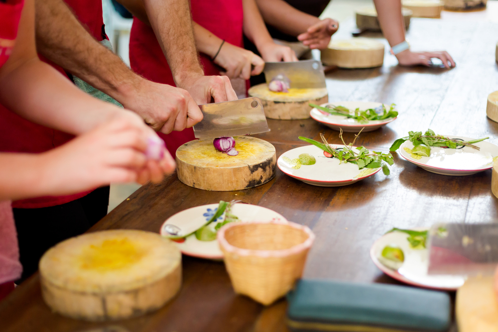 A group of adults take a cooking class together.