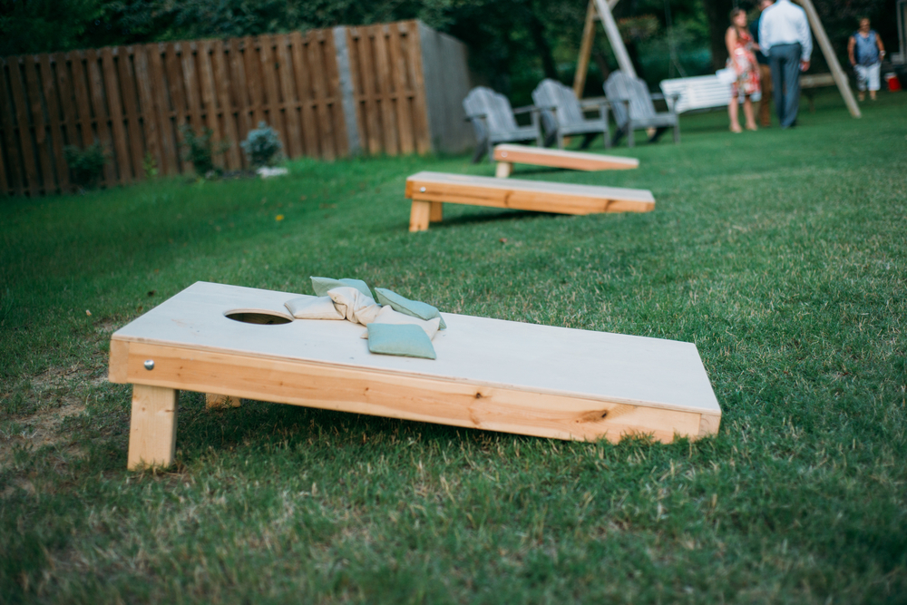 A row of corn hole boards in a backyard.